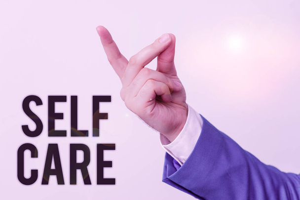 Handwriting text Self Care. Concept meaning the practice of taking action to improve one s is own health Isolated hand pointing with finger. Business concept pointing finger. - Photo, Image