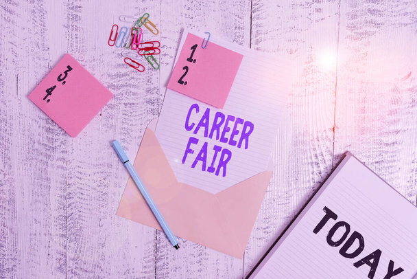 Word writing text Career Fair. Business concept for an event at which job seekers can meet possible employers Envelope sheet paper sticky notes ballpoint notepad clips wooden background. - Photo, Image