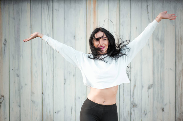 Portrait of a beautiful young woman in a white T-shirt with black hair. joy and laughter degenerate. positive emotions. Life style. beauty and youth. on a white background Positive and joyful emotions - Fotografie, Obrázek
