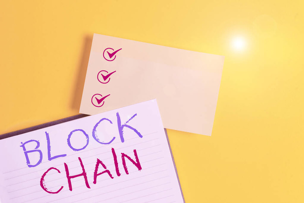 Conceptuele handschrift toont Block Chain. Business foto tekstsysteem waarin een record van transacties gemaakt in Bitcoin Leeg oranje papier met kopieerruimte op de gele tafel. - Foto, afbeelding