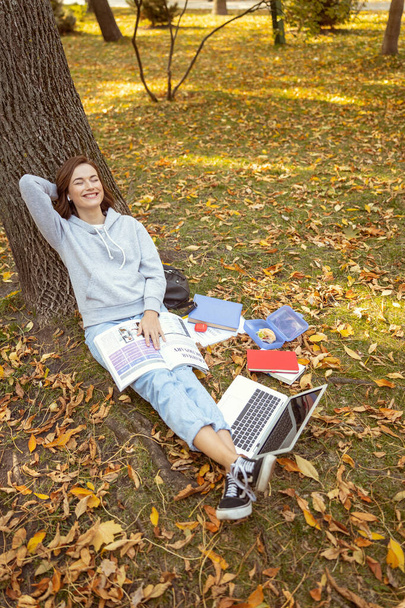 Positive delighted girl having rest in park - Fotó, kép