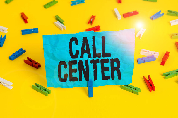 Conceptual hand writing showing Call Center. Business photo showcasing an office in which large numbers of telephone calls are handled Colored clothespin papers empty reminder yellow floor office. - Фото, изображение