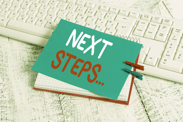 Writing note showing Next Steps. Business photo showcasing something you do or plan after you ve finished something else notebook reminder clothespin with pinned sheet light wooden. - Photo, Image