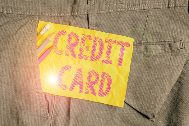 Wort schreiben Text Kreditkarte. Business-Konzept für Karte, die es Ihnen ermöglicht, Geld gegen eine Kreditlinie von Schreibgeräten und gelbem Zettelpapier in der Hosentasche des Mannes zu leihen. - Foto, Bild