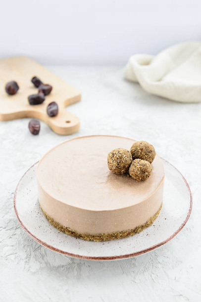 Chocolate raw cheesecake garnished with energy balls. Gluten free. - Photo, Image