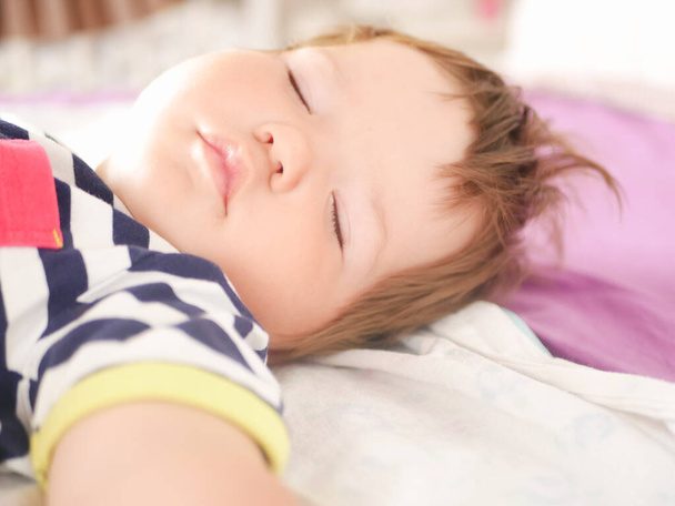 Bebek ebeveyn yatağında uyuyor. Kollarını açıp bebeğin huzurlu uykusuna daldı. Yakın plan. Çocuk 0-1 yaşında. Sevimli, sevimli bebek yatakta sakince uyuyor, güzel, sağlıklı bir rüyası var, ona bakılıyor. Etkiden - Fotoğraf, Görsel