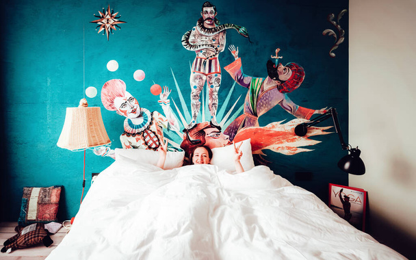 Девочка лежит в постели в интерьере спальни
 - Фото, изображение