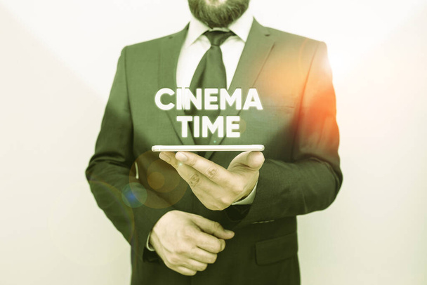 Word writing text Cinema Time. Business concept for which entertainment such showing movie scheduled to start Male human wear formal work suit hold smart hi tech smartphone use one hand. - Photo, Image