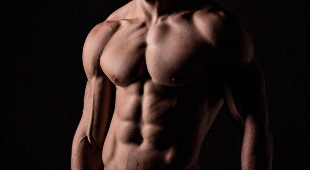 Musculosos hombres fuertes sobre fondo negro
 - Foto, imagen