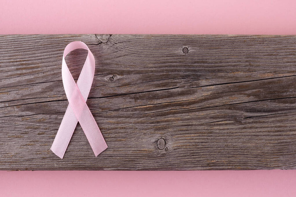 pink ribbon breast cancer on wooden background. Top view - Foto, imagen