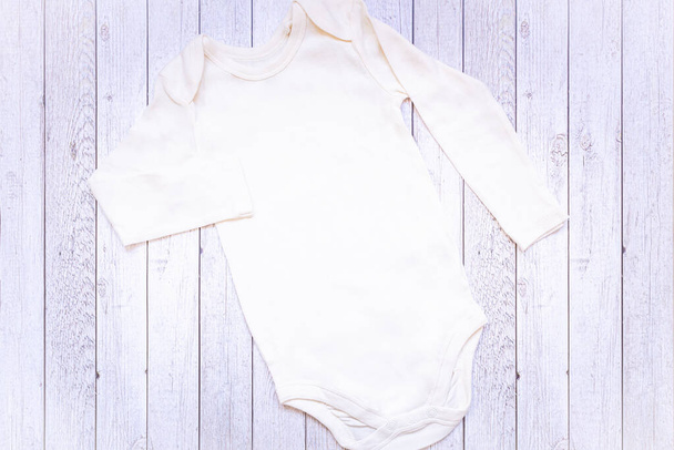 Traje de bebé unisex blanco en blanco recién nacido con juguete de oso de peluche. Lay plano Mockup
. - Foto, imagen