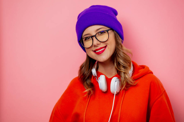 Style fille en sweat à capuche orange et chapeau violet avec écouteurs sur pi
 - Photo, image