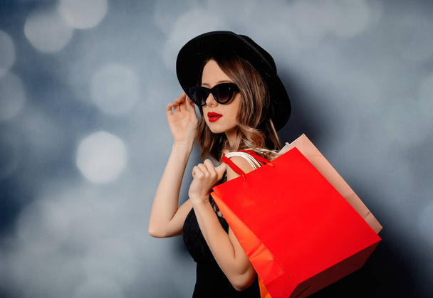 Tyyli nainen aurinkolasit ostoskassit harmaalla taustalla
  - Valokuva, kuva
