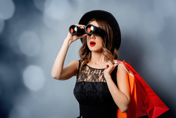 Mujer de estilo en gafas de sol con bolsas de compras y binoculares en g
 - Foto, imagen