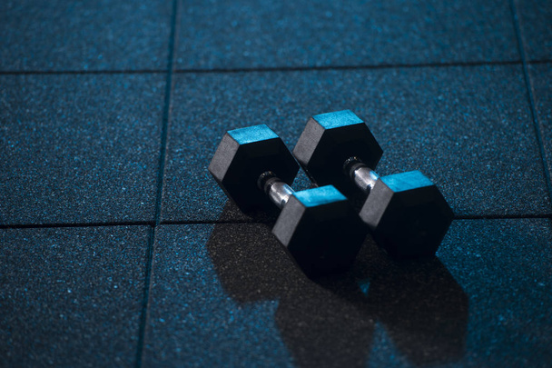 Fitness or bodybuilding concept background. Dumbbell exercise weights on the floo - Photo, Image