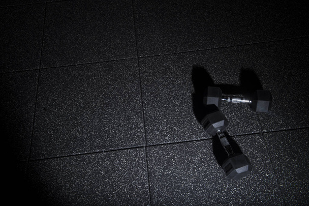Fitness oder Bodybuilding-Konzept Hintergrund. Kurzhantel übt Gewichte auf dem Parkett - Foto, Bild