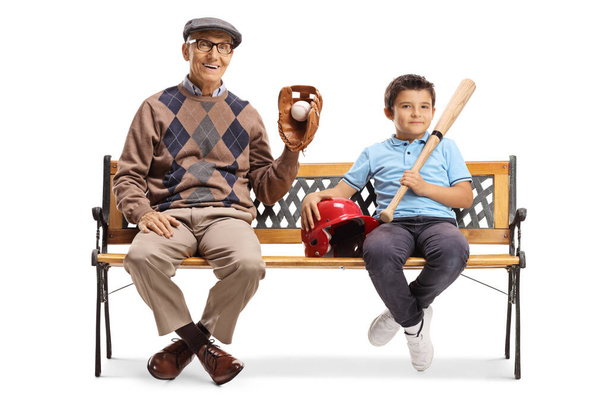 Junge und ein älterer Mann sitzen mit Baseball-Ausrüstung auf einer Bank. - Foto, Bild