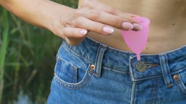 Primer plano de las manos de mujer sosteniendo la copa menstrual. Salud de las mujeres y concepto de cero residuos
 - Metraje, vídeo