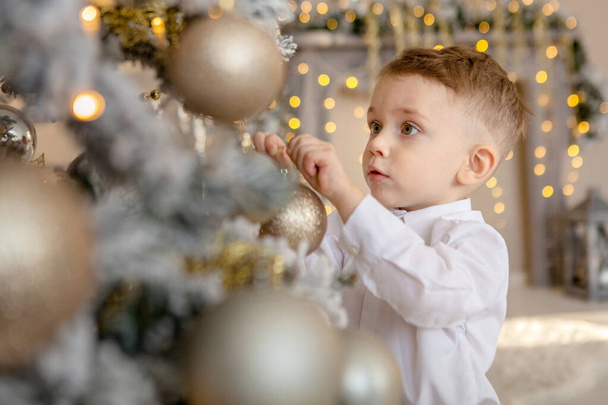 little boy decorates a Christmas tree for Christmas - Foto, Bild