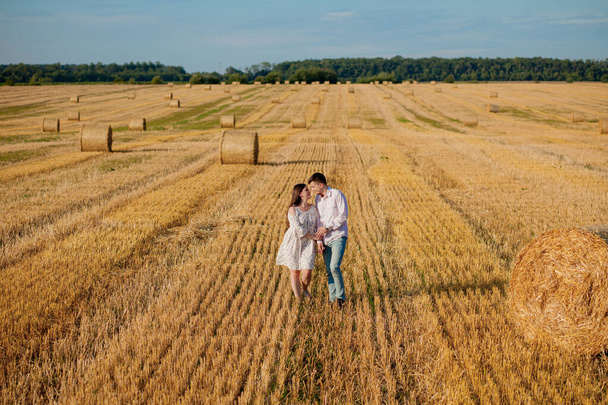 Happy young couple on straw, romantic people concept, beautiful landscape, summer season - Фото, изображение