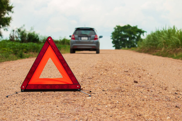 Triángulo rojo de advertencia. Céntrate en el triángulo rojo!, junto a la carretera rural
. - Foto, imagen