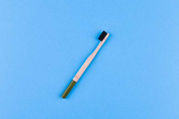 spazzolino da denti in legno su sfondo blu. Chiudere spazzolino da denti in legno su uno sfondo blu. spazzola ecologica
. - Foto, immagini