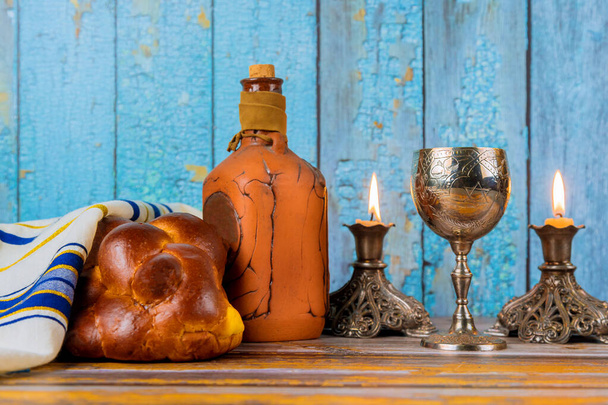 Shabbat a Barchesz kenyér egy fából készült asztal gyertyák és csésze bort. - Fotó, kép