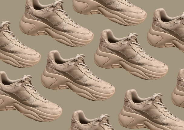 Коричневые спортивные кроссовки на коричневом фоне. Закрыть вид на моду Casual Sneakers с обувью. Кроссовки для мужчин и женщин. Мода Случайные кроссовки. Концепция баннера. Паттерн
 - Фото, изображение