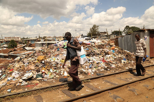 La gente camina cerca de montones de basura Nairobi Kenia África
 - Foto, imagen