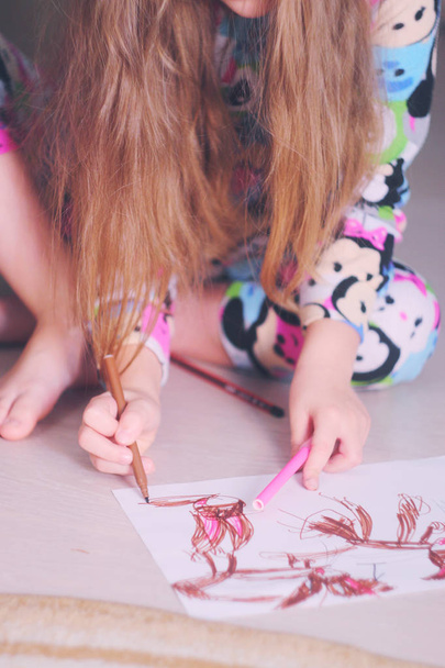 A girl draws her childhood fantasies with felt-tip pens on paper. - Foto, Imagen