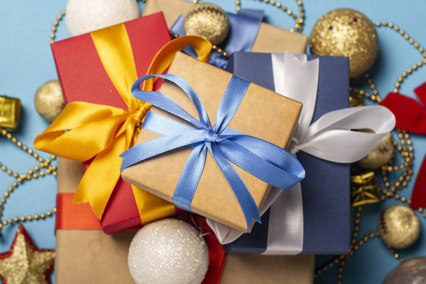 Una pila di regali e decorazioni natalizie su sfondo blu. Idea regalo per una persona cara, vacanza, Natale. Posa piatta, vista dall'alto
 - Foto, immagini