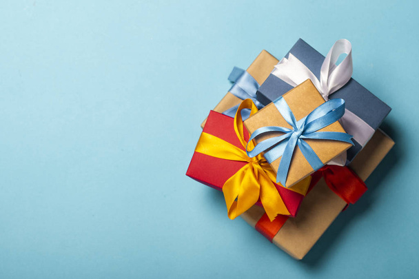 Куча подарков на синем фоне. Подарочная концепция для любимого человека, праздник, Рождество. Плоский, вид сверху
 - Фото, изображение