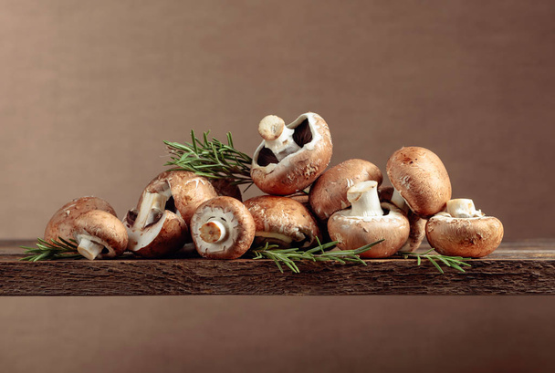 Fresh brown mushrooms champignon on a old wooden table. - Фото, изображение