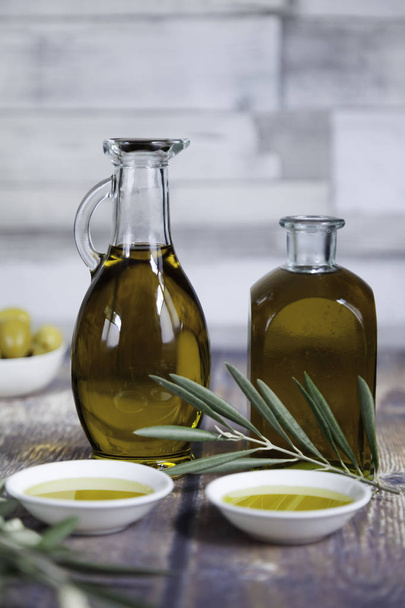 two oil bottles and olive leaves close-up - Foto, Imagen