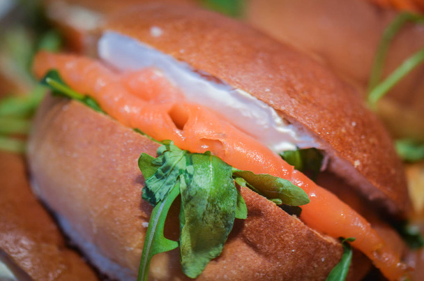 chutný čerstvý lososový sendvič s rukolovým salátem a sýrovou smetanou - Fotografie, Obrázek