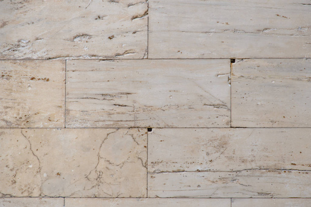 A fragment of the wall of the ancient temple in the Acropolis, built of smooth marble slabs. Background. Yellow-beige color. - Fotó, kép