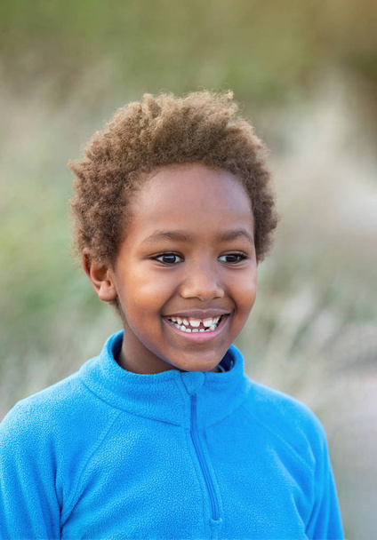 Χαρούμενο αφρικανικό παιδί με μπλε φανέλα - Φωτογραφία, εικόνα
