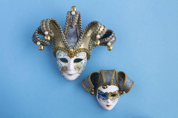 Две венецианские карнавальные маски в центре синего фона. Вид сверху. Копирование пространства
. - Фото, изображение
