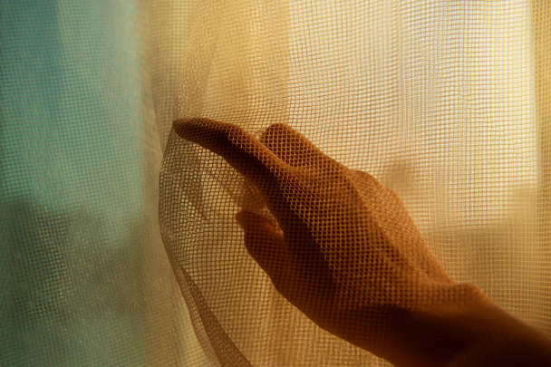 mano donna sotto dito punto tessuto netto alla finestra con oran
 - Foto, immagini