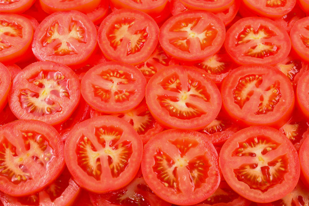 Tomatenhintergrund in Scheiben geschnitten. Ansicht von oben.  - Foto, Bild