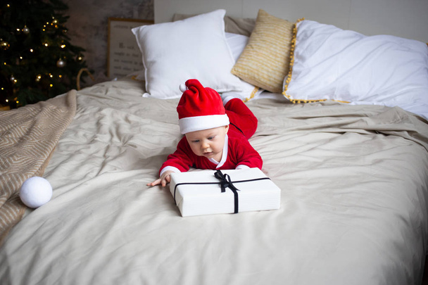 Little boy with a gift boxes on bed at home - Foto, immagini