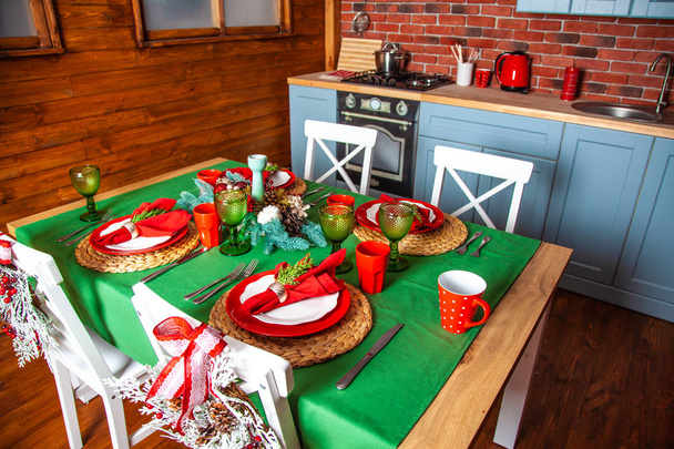 Slavnostní vánoční stolek, krásně zdobený v zelené a červené barvě, venkovský dřevěný dům, kuchyňský kout, Nový rok, zimní čas - Fotografie, Obrázek