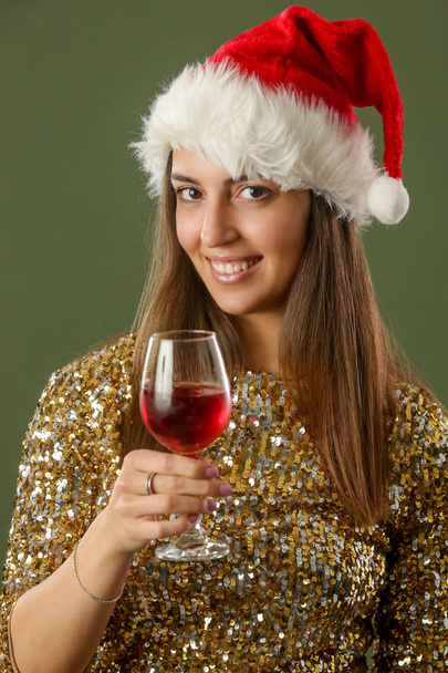 Szczęśliwa kobieta w złotym cekinowym stroju trzymając szklankę czerwonego wina, koncepcja Christmas party, zimowe wakacje - Zdjęcie, obraz
