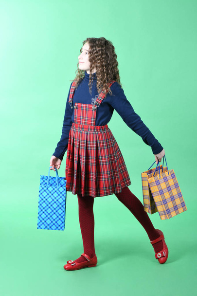 Kind mit einer Verpackung kariert Textur isoliert auf weißem Hintergrund. Mädchen mag Einkaufen im Verkauf Saison. Weihnachtsgeschenk, Einkaufen.  - Foto, Bild