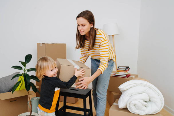 Son helping mother to pack, they are moving out from an old apartment. - Fotoğraf, Görsel