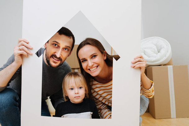 Family portrait, taken through house resembling frame - 写真・画像