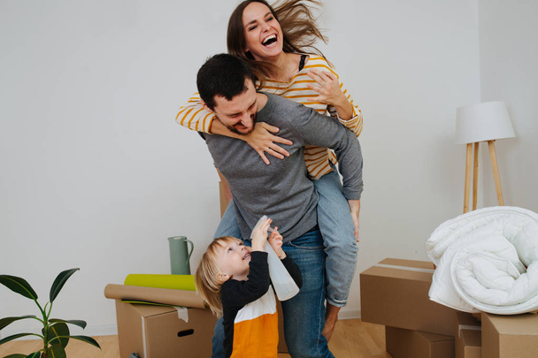Family celebrating moving into a new apartment. They are having fun together. - Foto, Bild