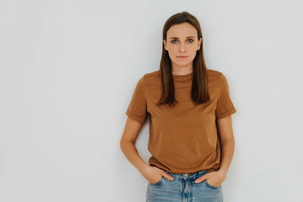 Portrait of a woman, leaning on the wall, with hands in pockets. Half length - Foto, Bild
