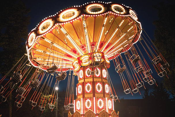 Verlichte schommel ketting carrousel in pretpark 's nachts - Foto, afbeelding