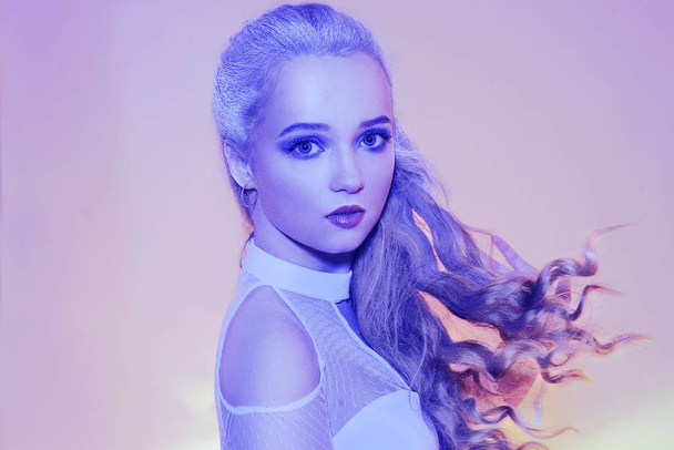 The snow queen in neon. Winter woman in a chic white dress, and snowy white hair. Girl with blue make-up. Winter beauty, stylization. Woman winter, snow, beauty, fashion. - Foto, imagen